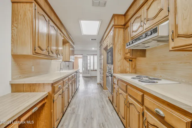 a kitchen with stainless steel appliances granite countertop a stove and a wooden floors
