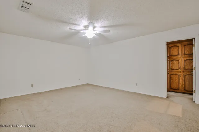 an empty room with a window and a fan