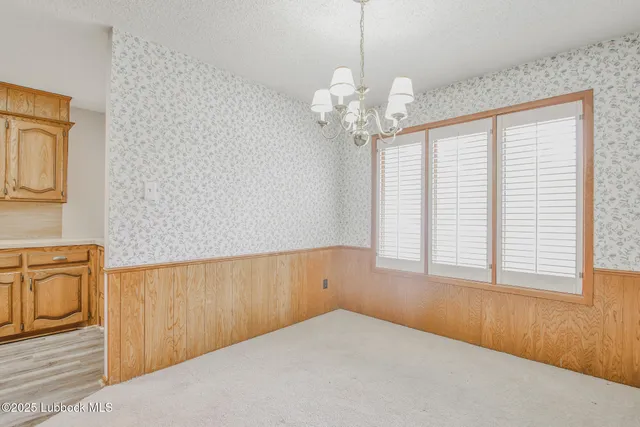 a view of a livingroom with a chandelier fan and windows