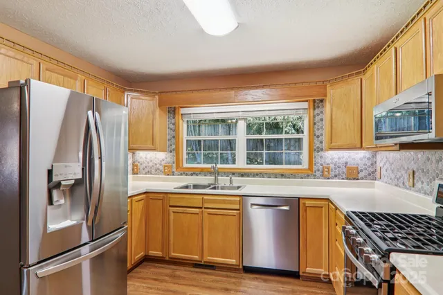 a kitchen with stainless steel appliances granite countertop a refrigerator and a sink