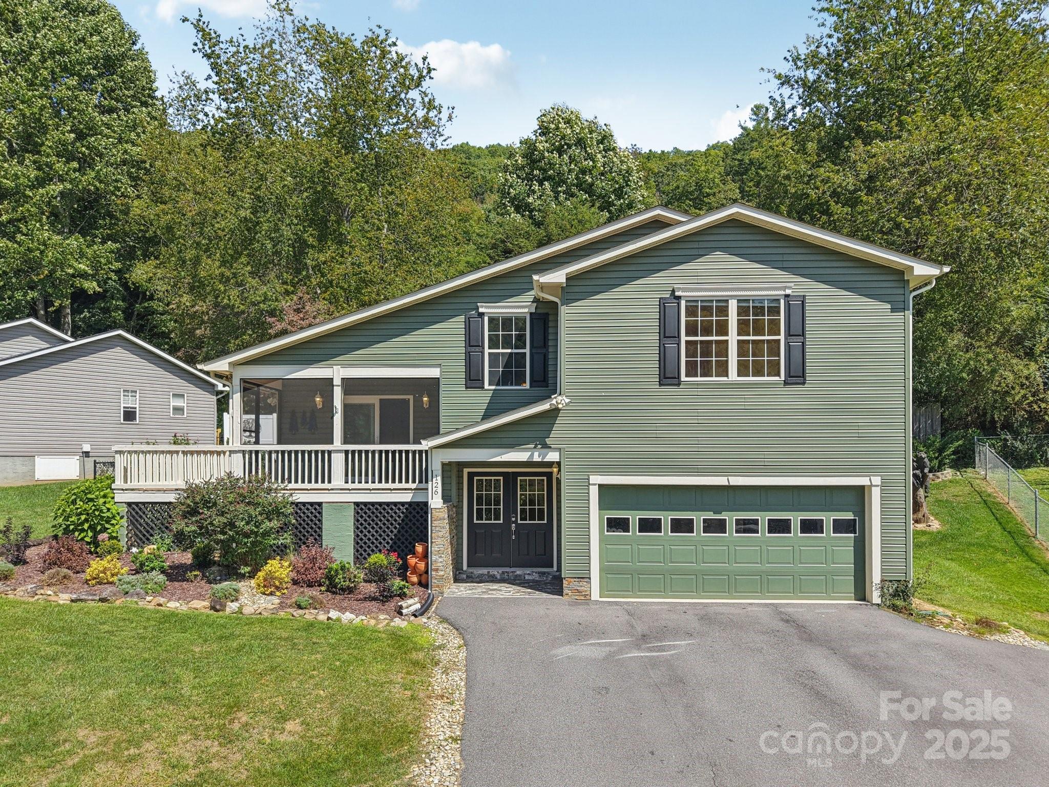 126 Pasco Loop Waynesville, NC 28785 - Photo 2 of 44 a front view of a house with a yard and garage