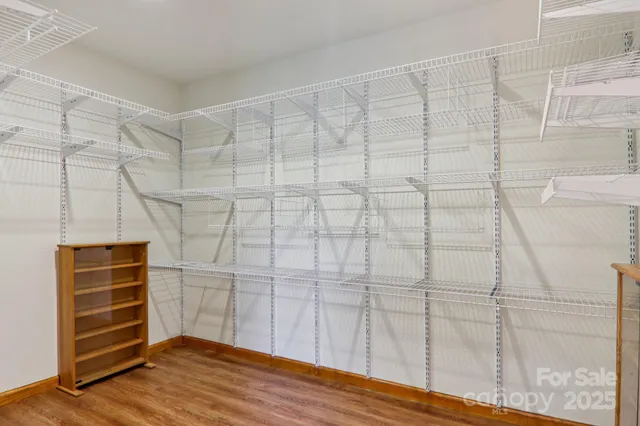 a view of an empty room with wooden floor and cabinet