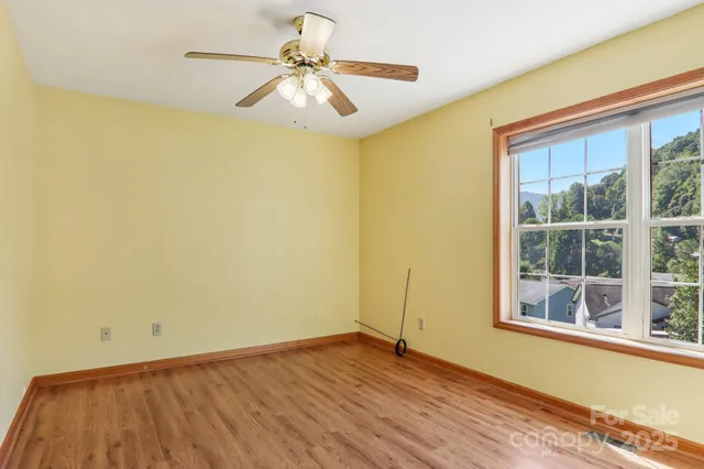 an empty room with a window and wooden floor
