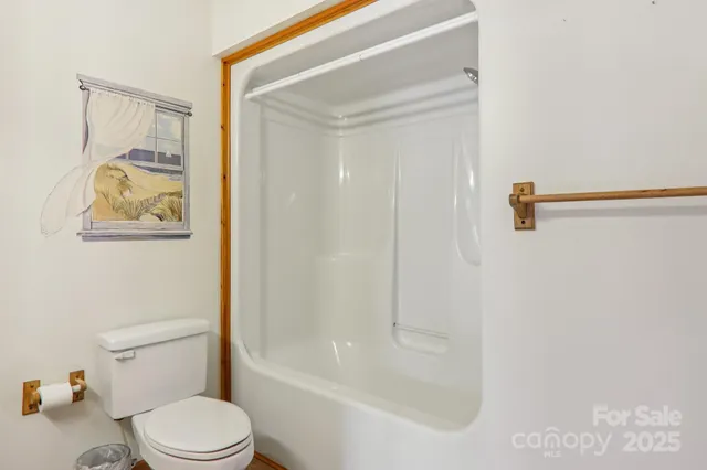 a white toilet sitting next to a bath tub