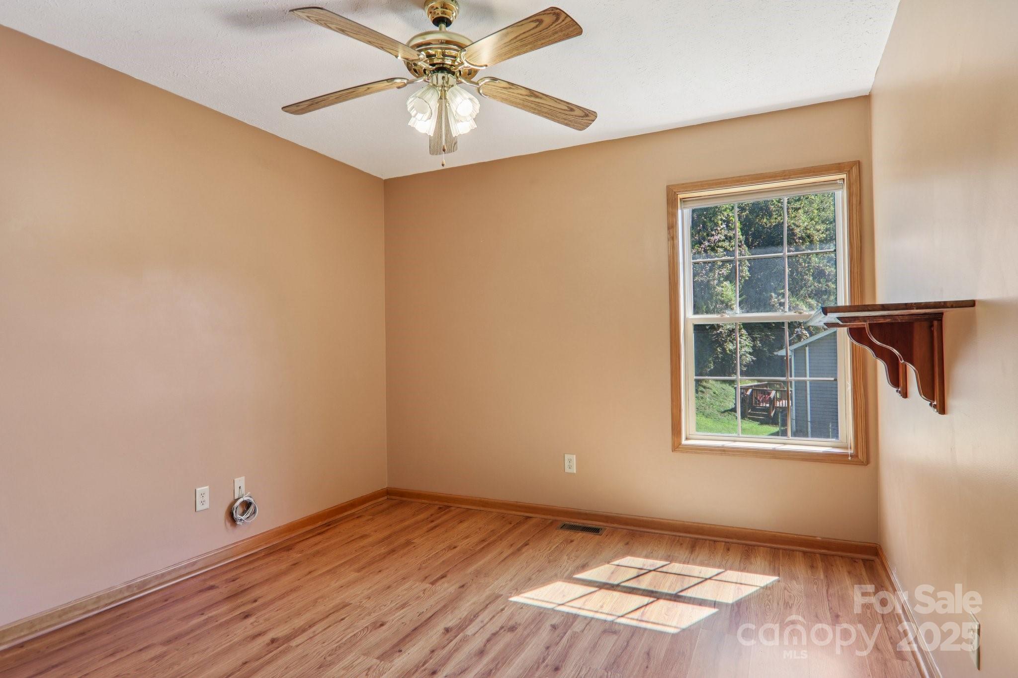 126 Pasco Loop Waynesville, NC 28785 - Photo 30 of 44 an empty room with wooden floor chandelier fan and windows