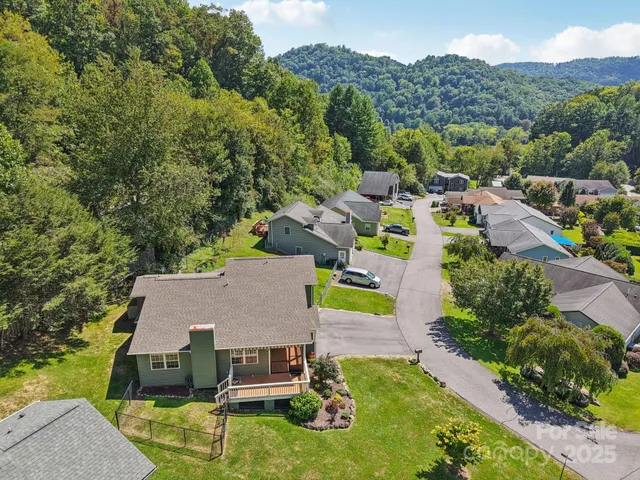 an aerial view of a house with swimming pool and mountains