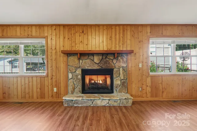 an empty room with wooden floor and a fireplace