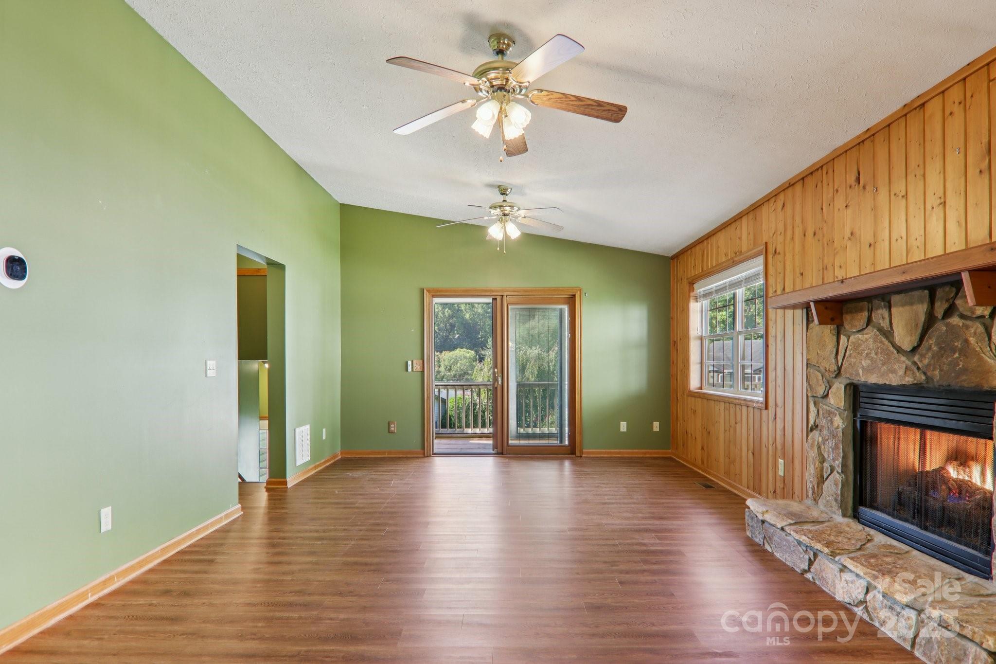 126 Pasco Loop Waynesville, NC 28785 - Photo 8 of 44 a view of an empty room with window fireplace and wooden floor
