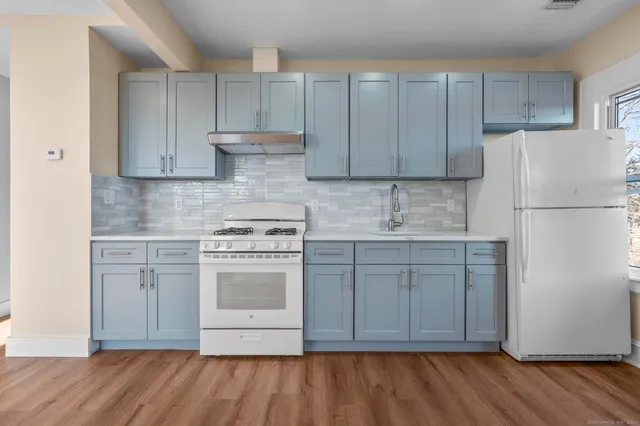 a kitchen with a sink cabinets and wooden floor