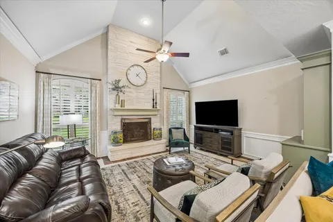 a living room with furniture a fireplace and a flat screen tv