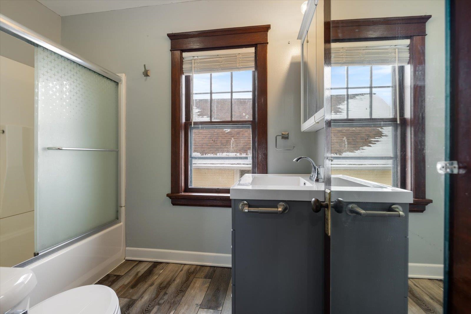 3070 Restormel Street Duluth, MN 55806 - Photo 28 of 48 Full bath featuring vanity, dark wood finished floors, and bath / shower combo with glass door