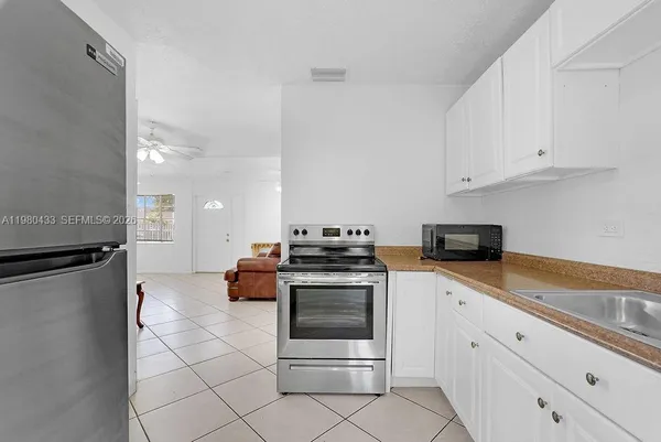a kitchen with granite countertop white cabinets and white appliances