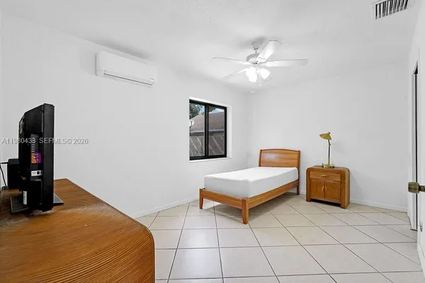 a bedroom with a bed and a potted plant
