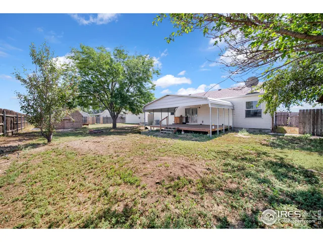 a backyard of a house with table and chairs