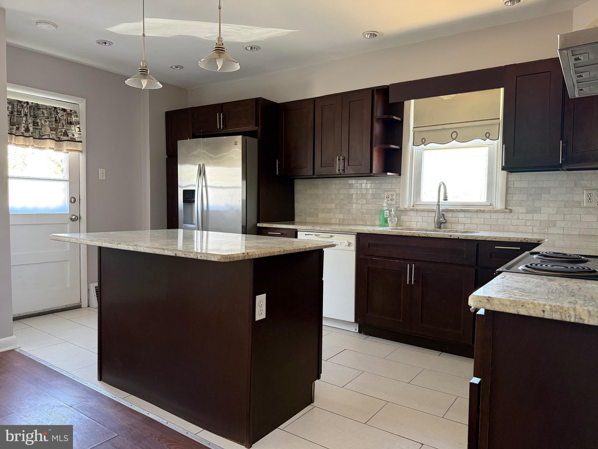 9083 Convent Avenue Philadelphia, PA 19136 - Photo 6 of 22 a kitchen with granite countertop cabinets a sink a window and stainless steel appliances