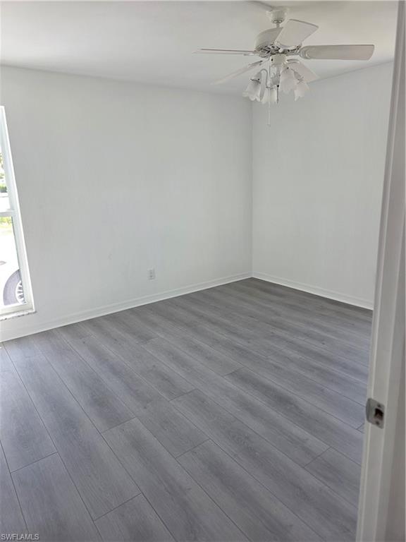 1 Knights Bridge Road, Unit A1 Naples, FL 34112 - Photo 11 of 25 an empty room with wooden floor fan and windows