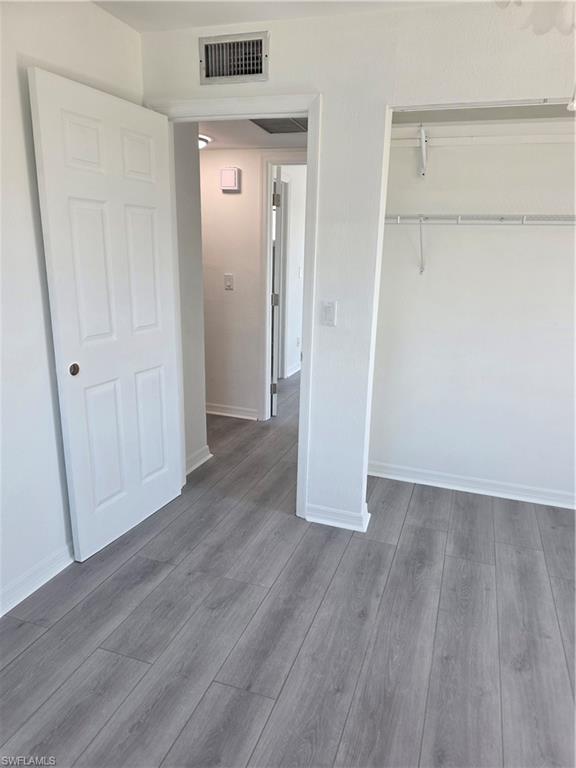 1 Knights Bridge Road, Unit A1 Naples, FL 34112 - Photo 18 of 25 an empty room with wooden floor and closet