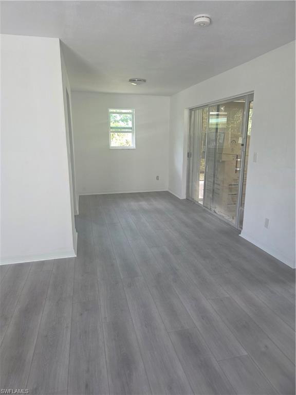 1 Knights Bridge Road, Unit A1 Naples, FL 34112 - Photo 22 of 25 an empty room with wooden floor and windows