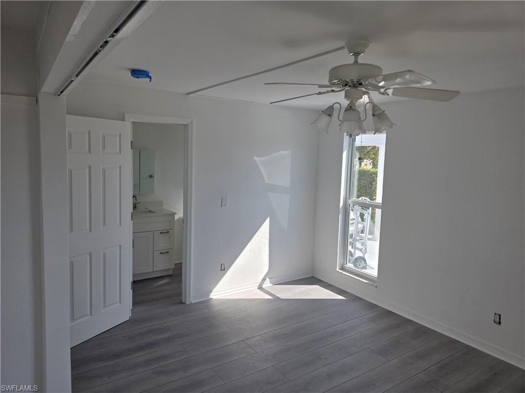 1 Knights Bridge Road, Unit A1 Naples, FL 34112 - Photo 9 of 25 wooden floor in an empty room with a window