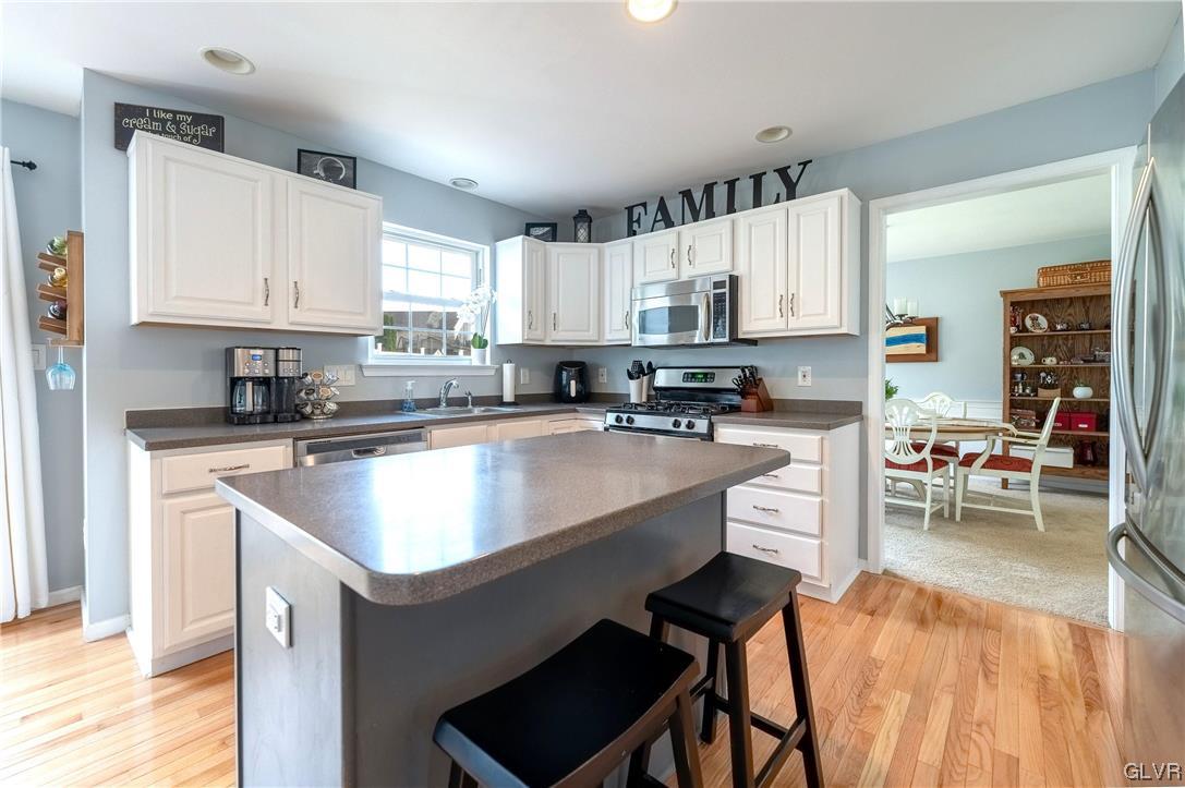 4556 Brighton Road Lower Macungie Township, PA 18062 - Photo 15 of 48 a kitchen with stainless steel appliances granite countertop a sink a stove a refrigerator a kitchen island and chairs with wooden floor