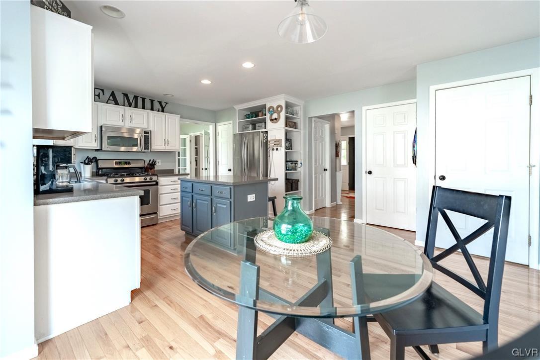 4556 Brighton Road Lower Macungie Township, PA 18062 - Photo 16 of 48 a kitchen with stainless steel appliances kitchen island granite countertop a dining table chairs and a refrigerator