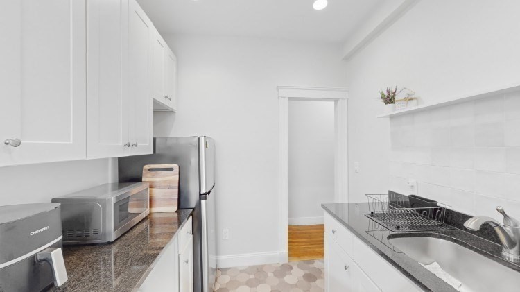 56 Charlesgate East, Unit 138 Boston, MA 02215 - Photo 2 of 17 a kitchen with stainless steel appliances granite countertop a sink stove and refrigerator