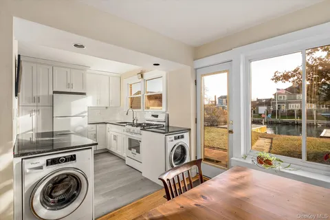 a kitchen with sink a washer and dryer with wooden floor