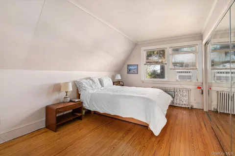 a bedroom with a bed and a wooden floor