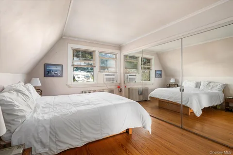 a spacious bedroom with a bed and wooden floor