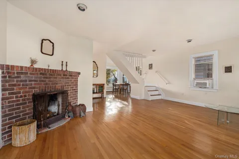 a living room with wooden floor and a fireplace