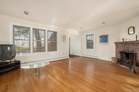 a view of empty room with wooden floor and fireplace