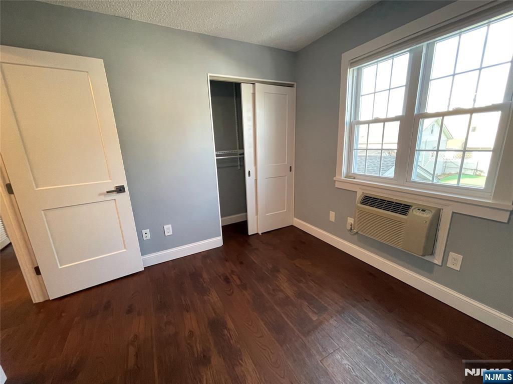 52 Reilly Court, Unit 1 Hackensack, NJ 07601 - Photo 18 of 25 an empty room with wooden floor and windows