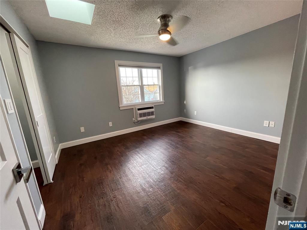 52 Reilly Court, Unit 1 Hackensack, NJ 07601 - Photo 19 of 25 an empty room with wooden floor and windows
