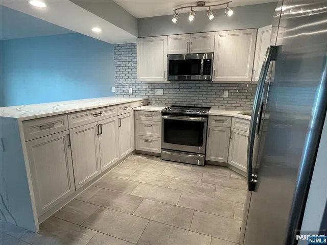 a large kitchen with a stove a refrigerator and a sink
