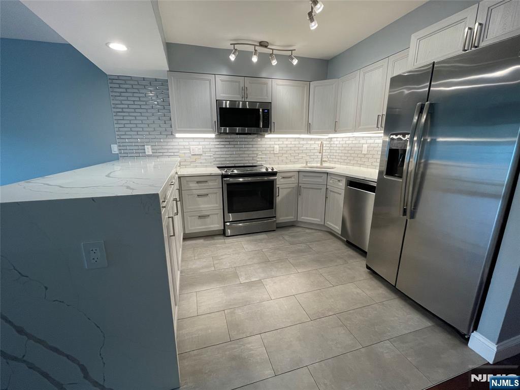 52 Reilly Court, Unit 1 Hackensack, NJ 07601 - Photo 4 of 25 a large kitchen with a stove a refrigerator and a sink