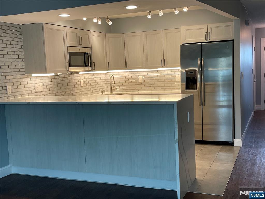 52 Reilly Court, Unit 1 Hackensack, NJ 07601 - Photo 5 of 25 a kitchen with kitchen island a counter top space cabinets and stainless steel appliances
