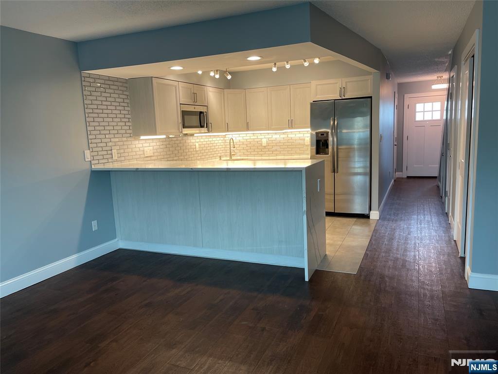 52 Reilly Court, Unit 1 Hackensack, NJ 07601 - Photo 8 of 25 an open kitchen with a sink and wooden floor