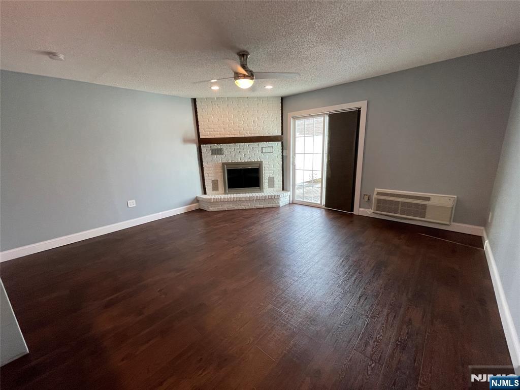 52 Reilly Court, Unit 1 Hackensack, NJ 07601 - Photo 10 of 25 an empty room with wooden floor fireplace and windows