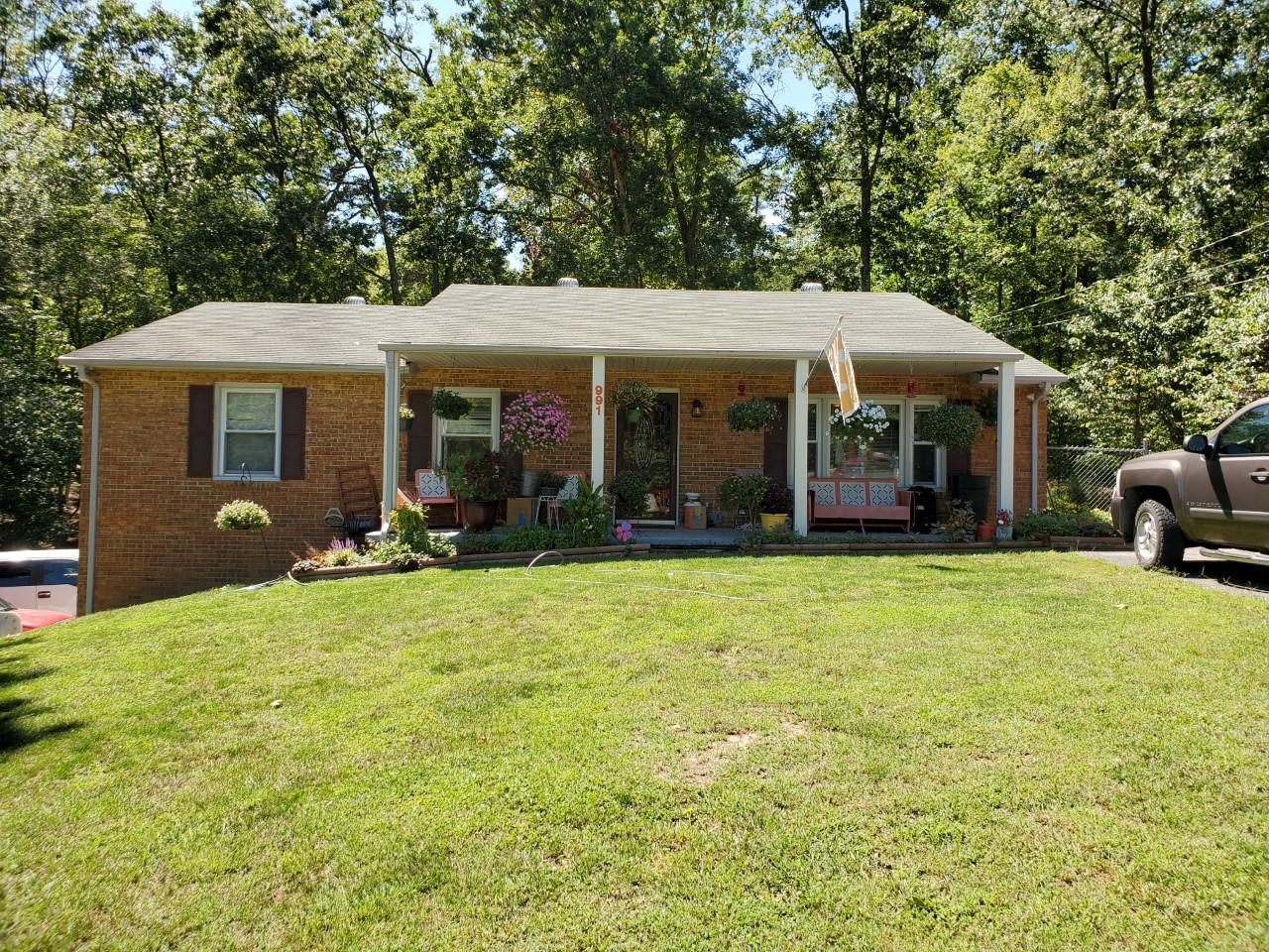 a view of an house with backyard and porch