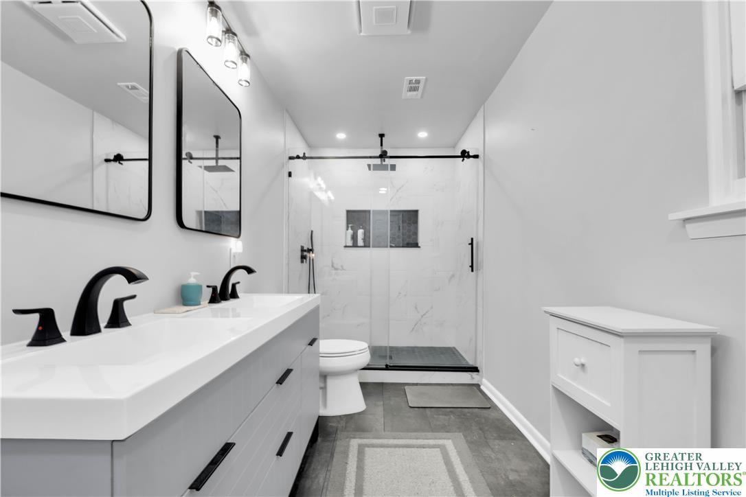 2011 Greenwood Road Allentown, PA 18103 - Photo 36 of 52 A well-lit, contemporary bathroom boasts a spacious walk-in shower and a double vanity for optimal functionality.