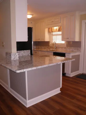 a kitchen with kitchen island granite countertop cabinets and stainless steel appliances
