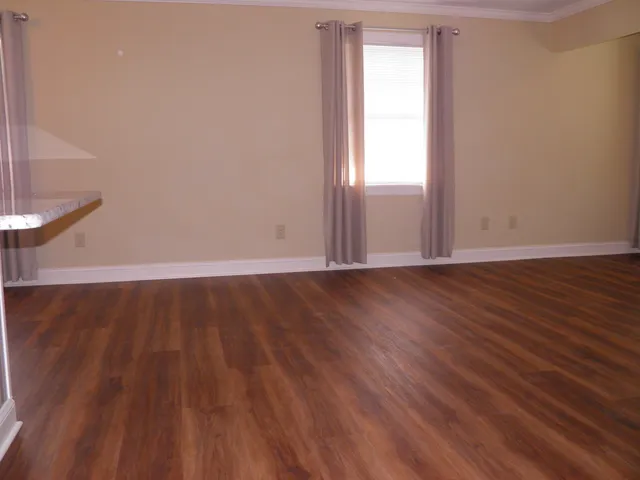 an empty room with wooden floor and sliding door