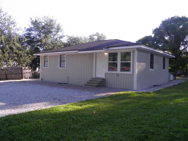 a view of backyard of house with green space