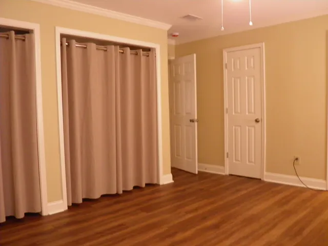 an empty room with wooden floor and closet