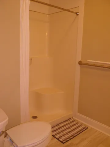 a white toilet sitting next to a shower