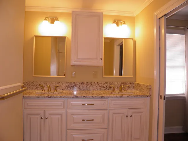 a bathroom with a granite countertop sink and a mirror