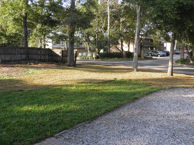 a view of backyard of house with wooden fence