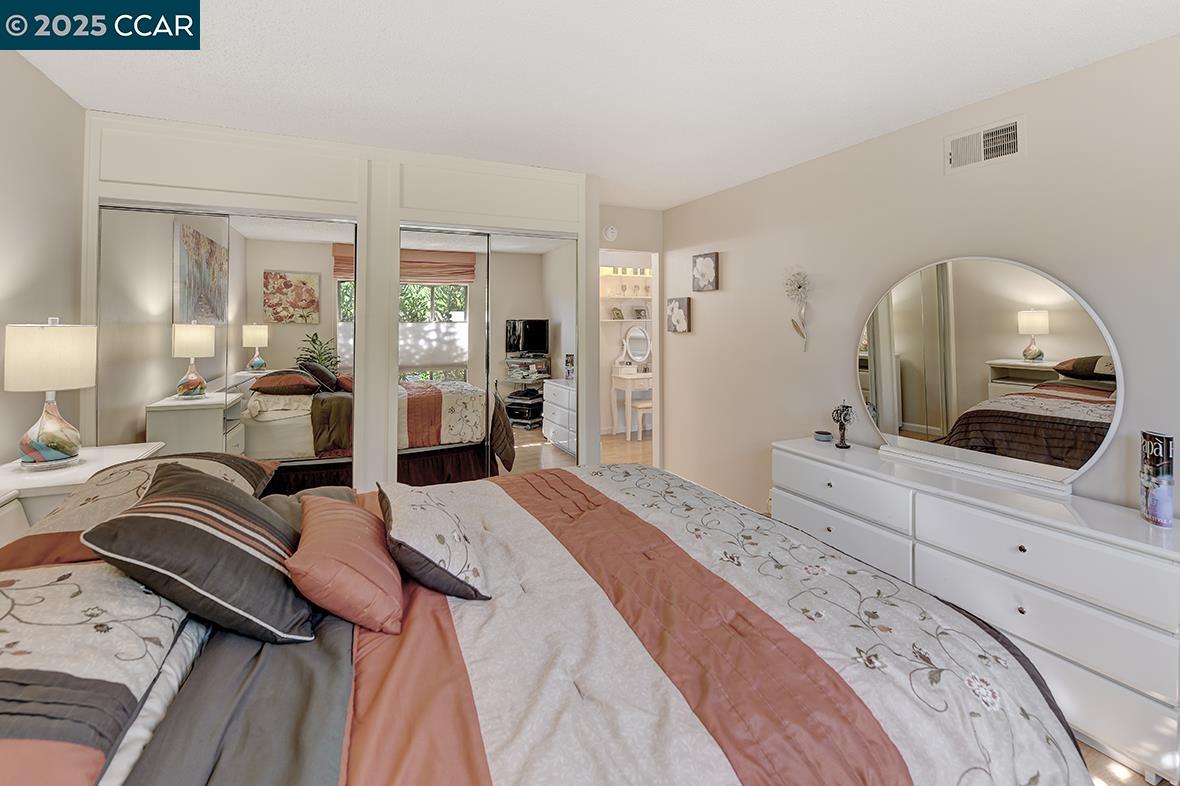 2148 Golden Rain Road, Unit 1 Walnut Creek, CA 94595 - Photo 26 of 48 a bedroom with a bed a mirror and lamp