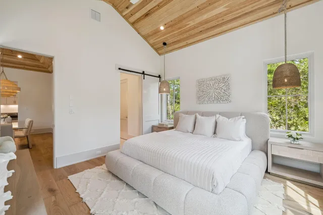 a bedroom with a bed chandelier and a window