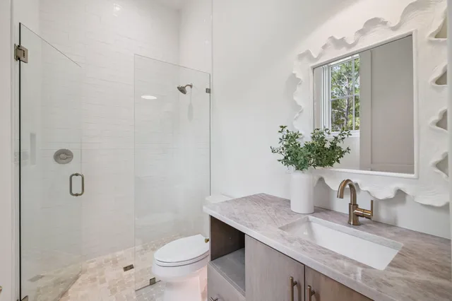 a bathroom with a granite countertop sink a toilet and shower